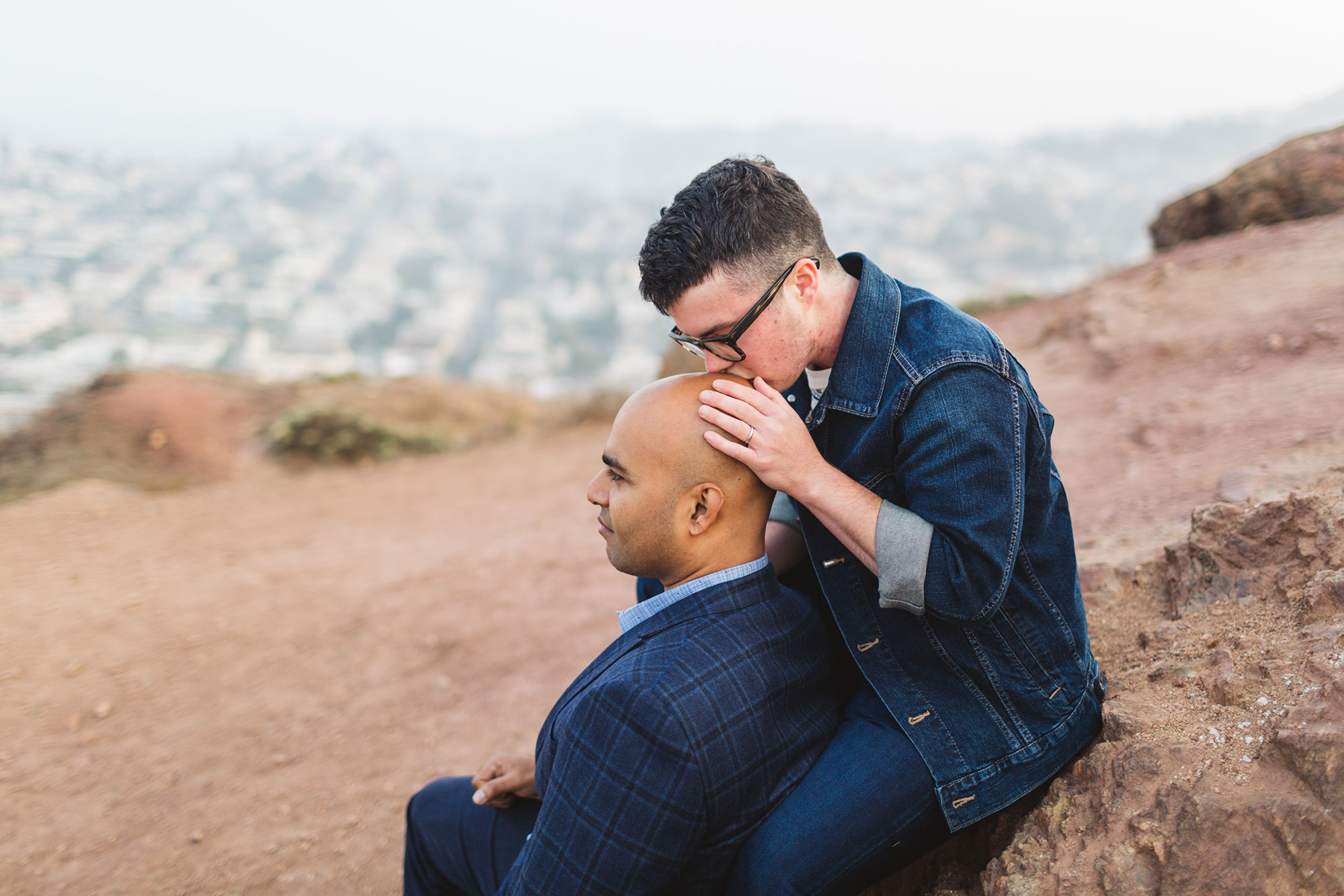 LGBTQ couple at san francisco's corona heights one kissing the other's head