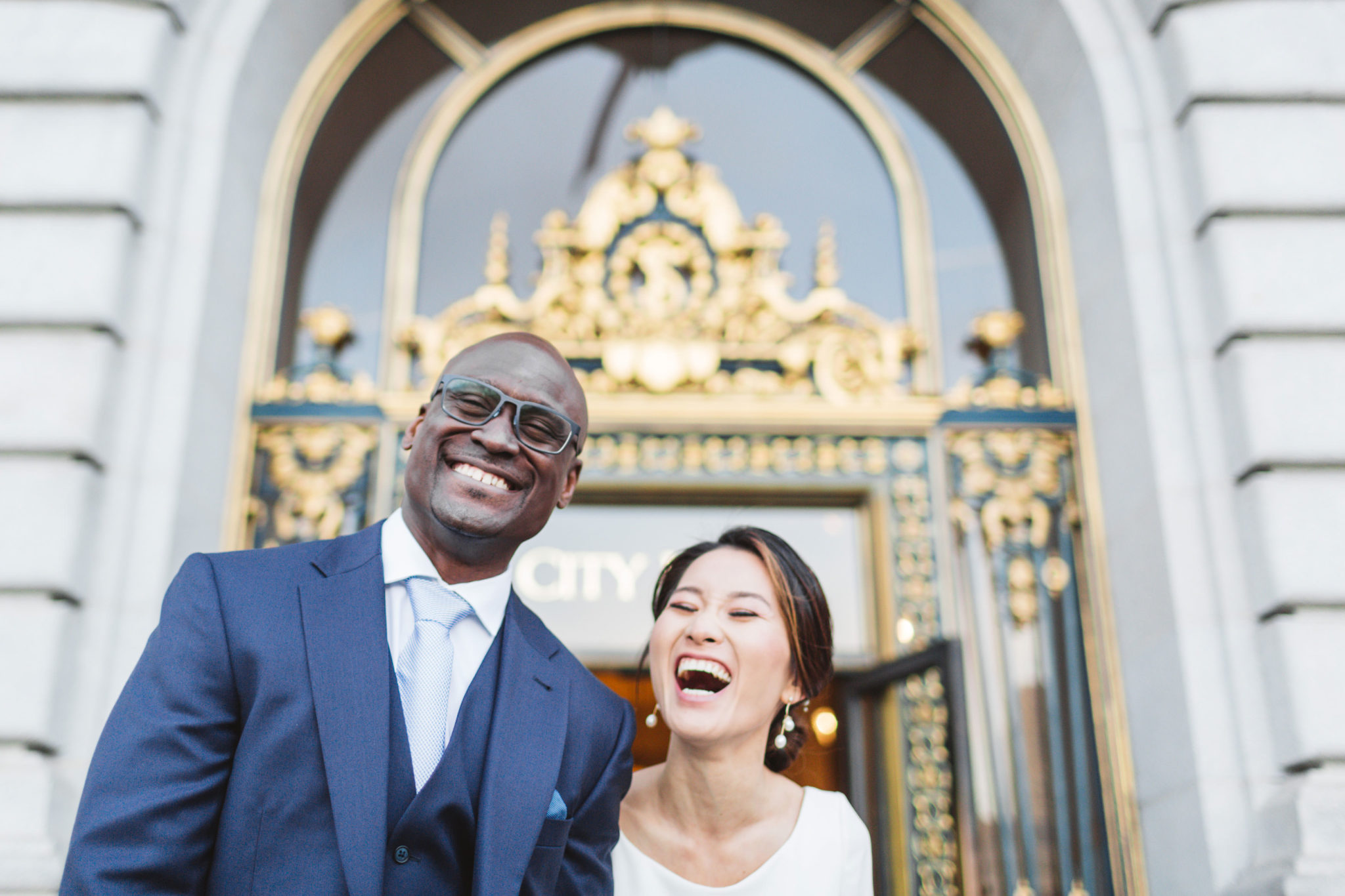 japanese bride and nigerian groom just married leaving City Hall san Francisco through iconic doors