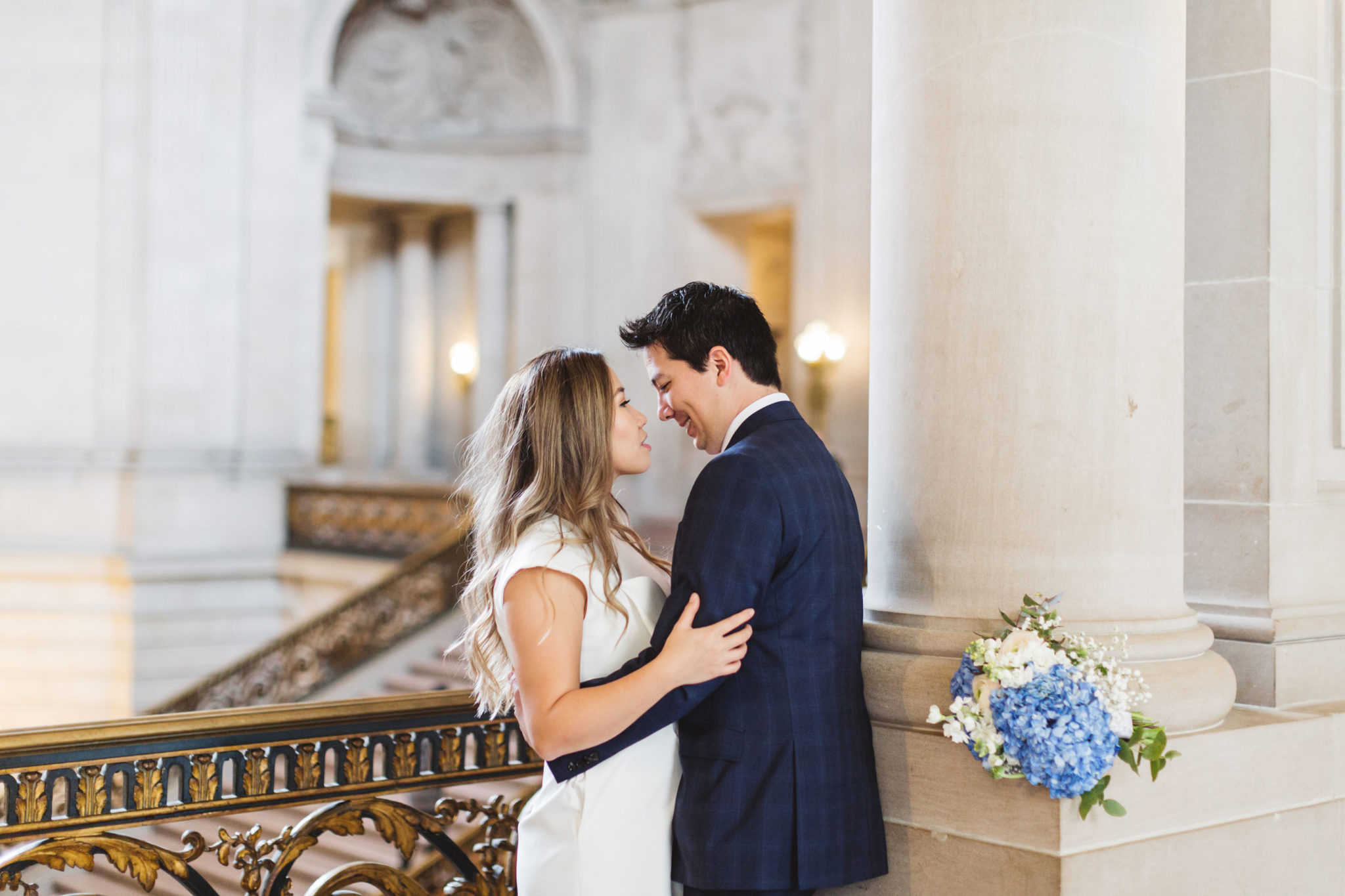 A sweet San Francisco City Hall wedding of a Vietnamese American couple, as they pose for pictures on the 2nd floor of the iconic San Francisco landmark on their wedding day | Photo by Zoe Larkin Photography