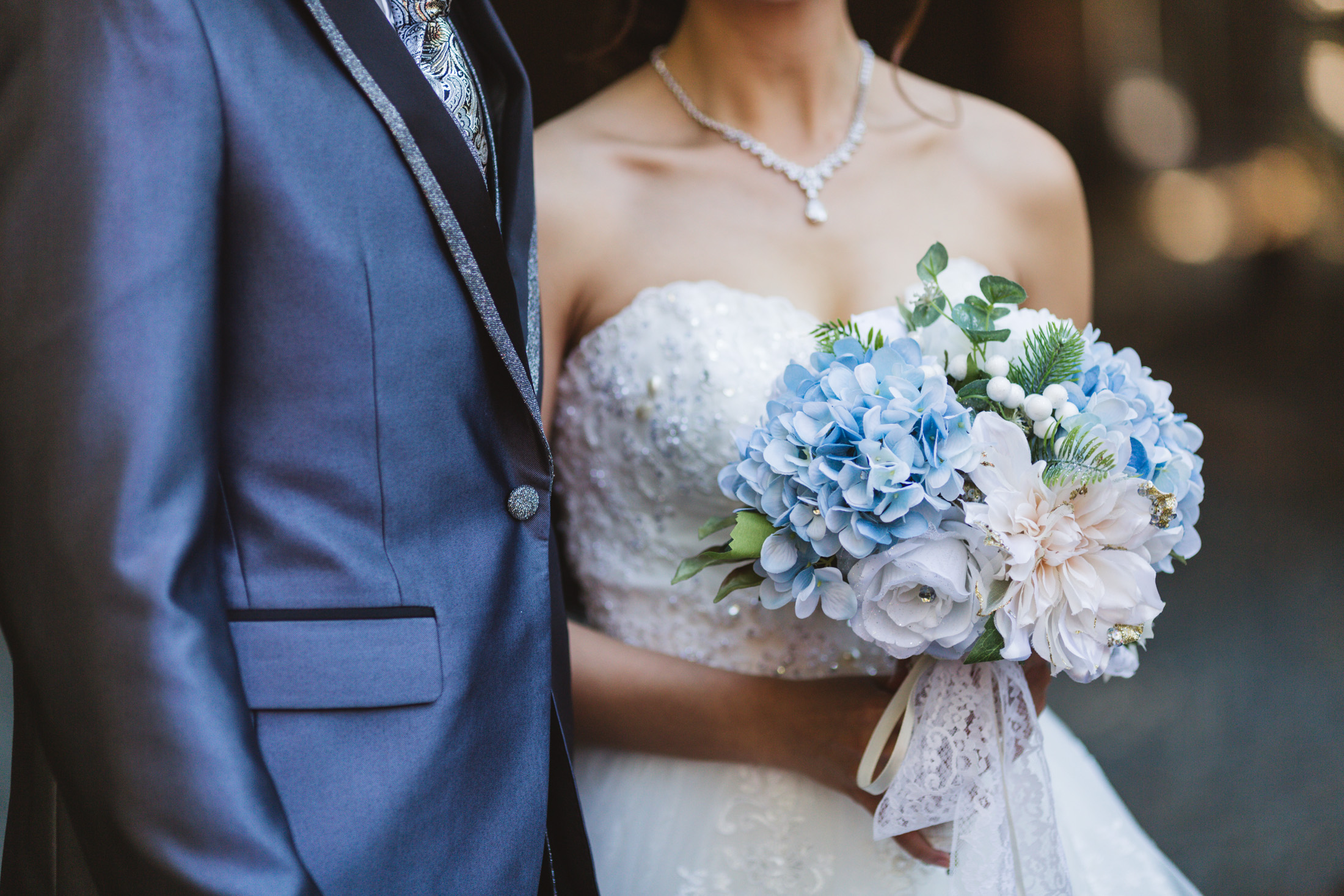 close up of bride with blue wedding bouquet with hydrangeas
