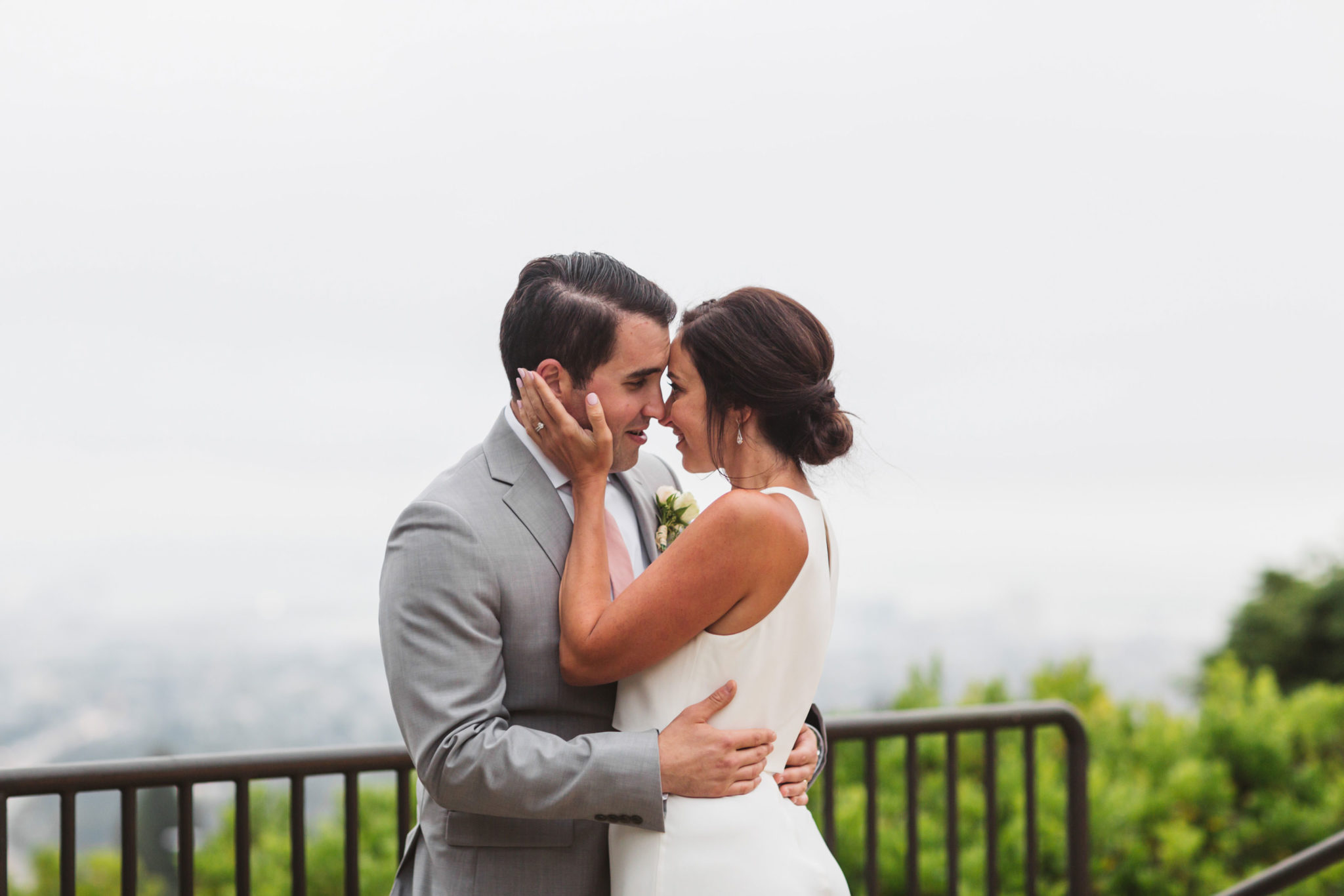 couple kissing at the highlands country club in oakland with the foggy skyline behind them | Zoe Larkin Photography